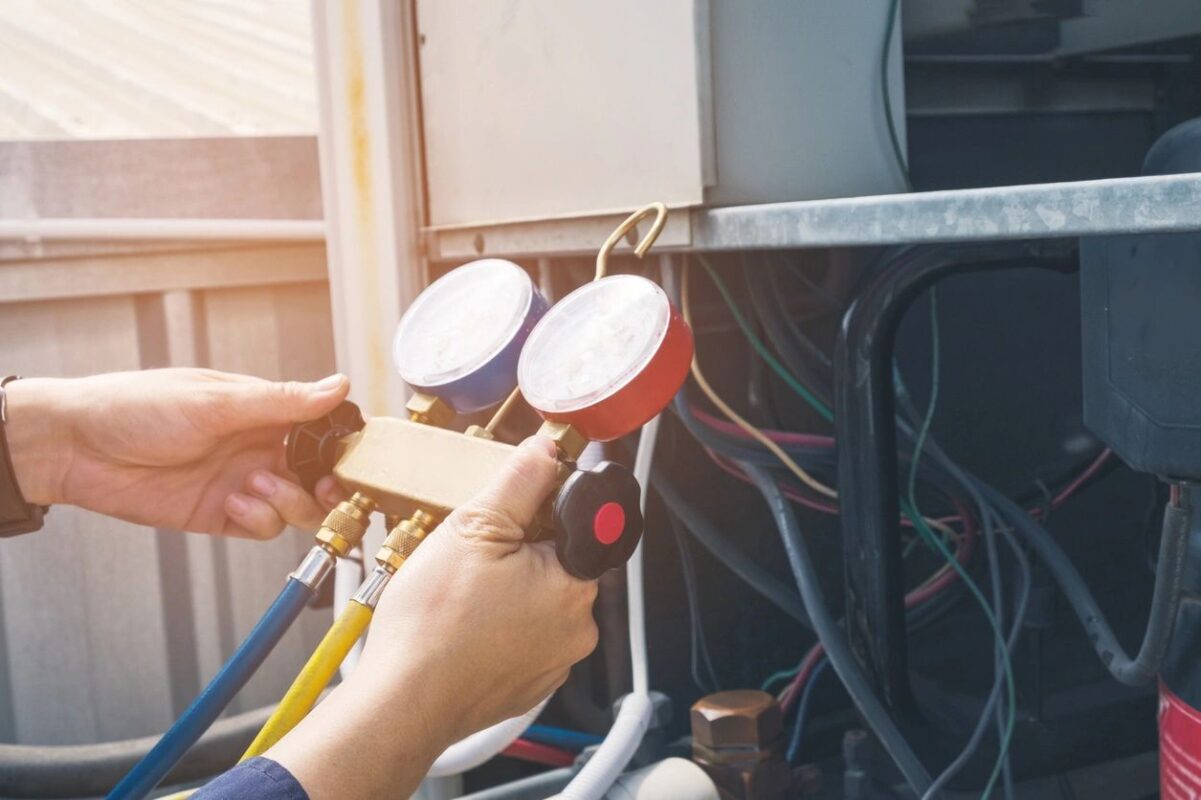 HVAC technician checking air conditioning pressure gauges in Boston MA