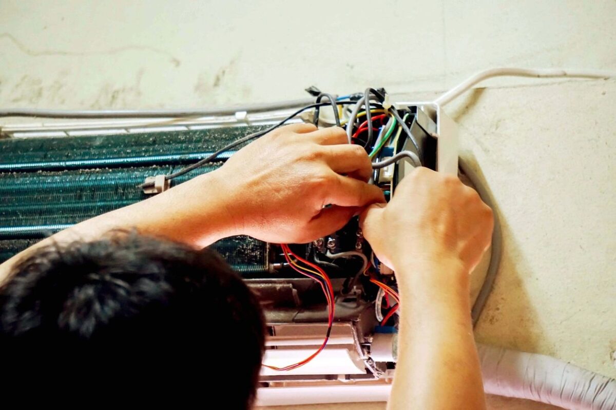 HVAC technician repairing air conditioning unit in Boston MA